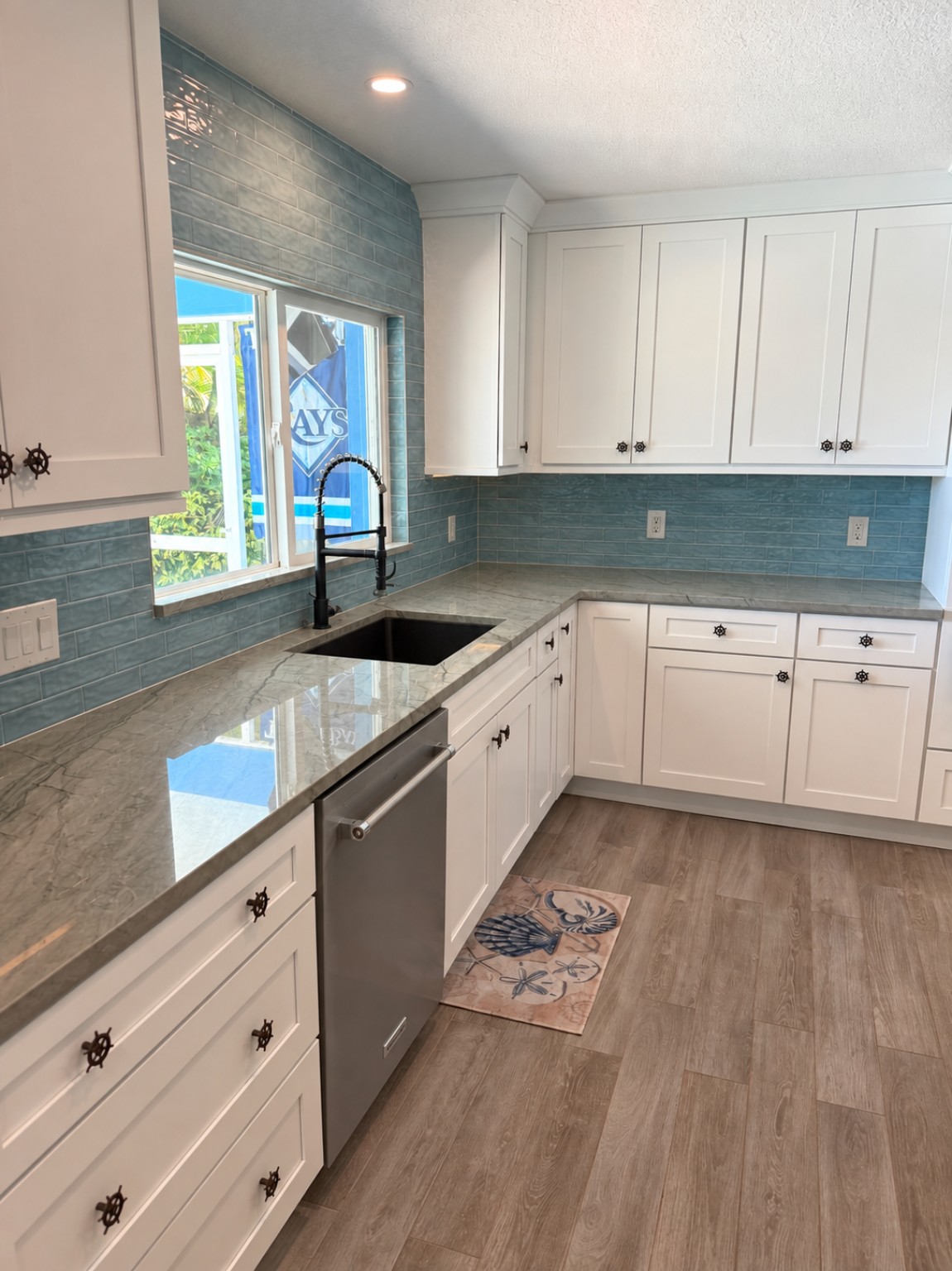 White kitchen cabinets, blue tile backsplash and stone countertops