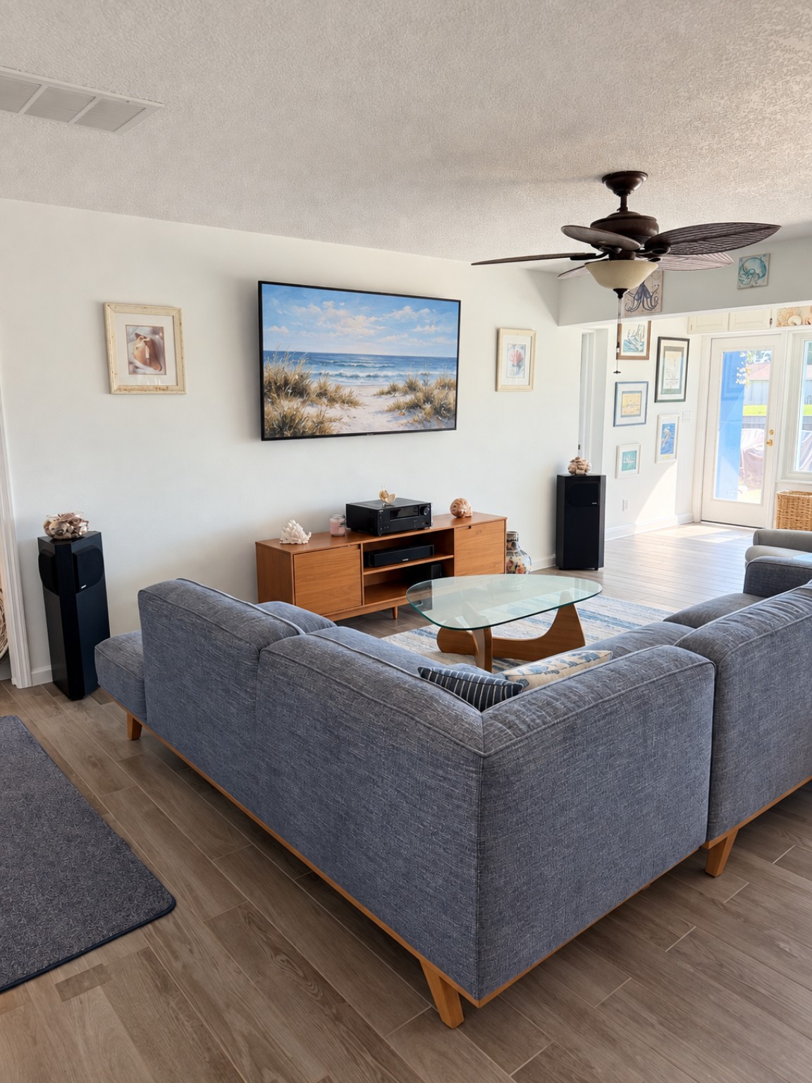 Sitting room with a gray sectional and glass coffee table