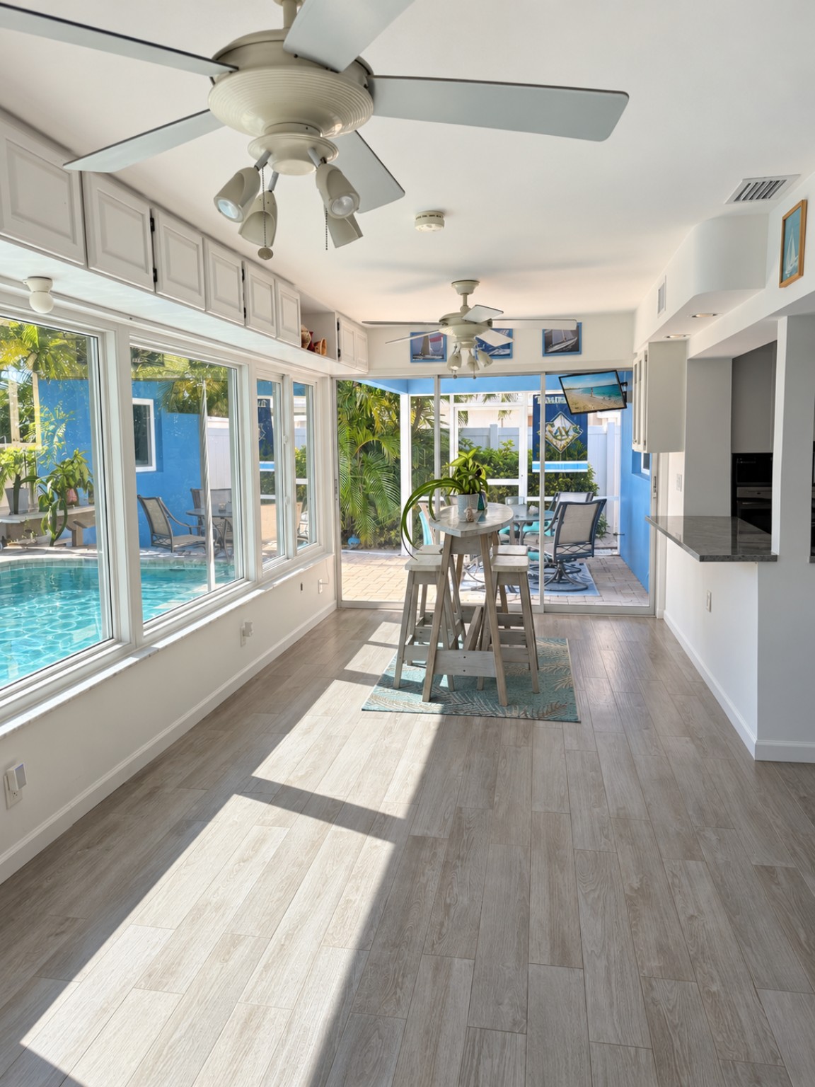 Sunroom with windows overlooking the pool